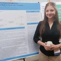 Kylah Allman standing in front of her poster presentation